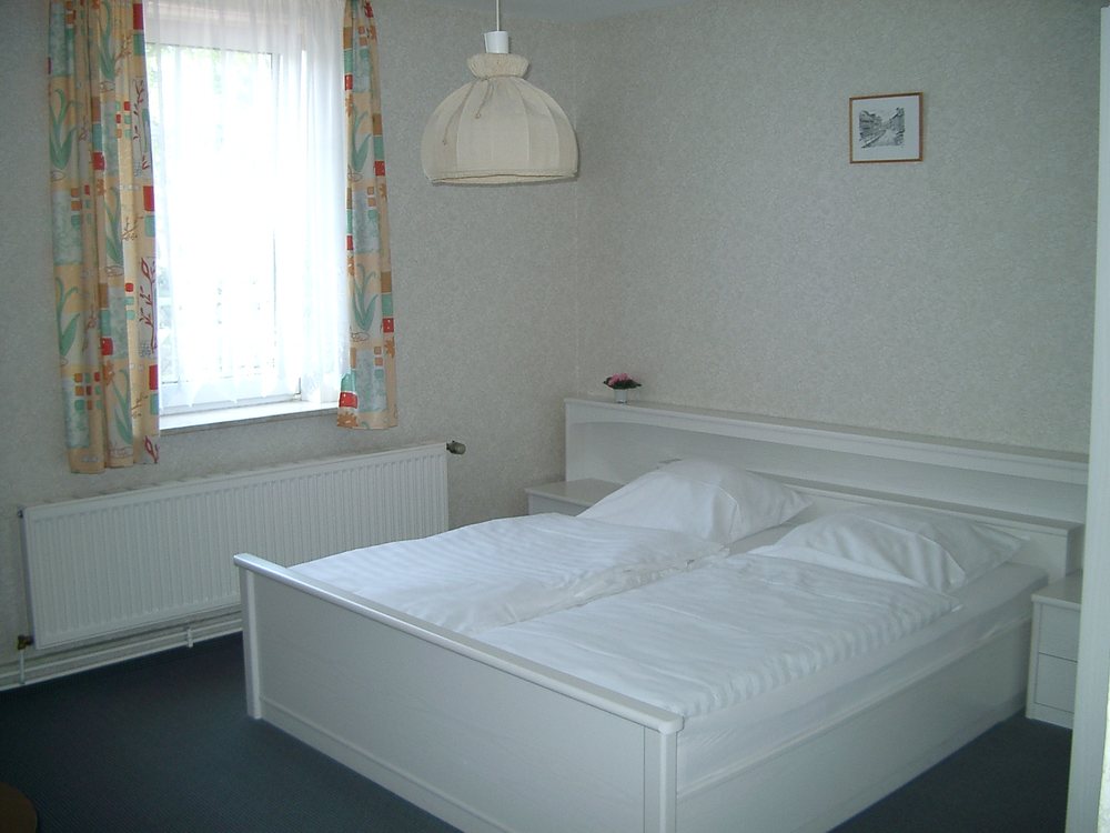 Doppelzimmer mit weißem Bett im Gasthaus Zur Tanne